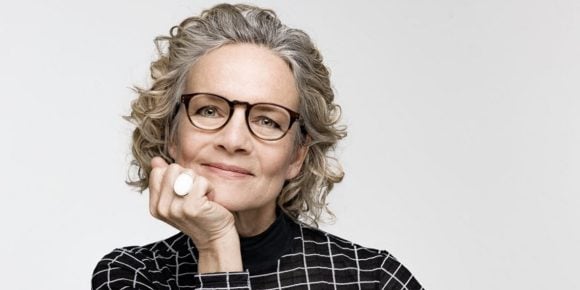 Woman in glasses posing in front of a camera